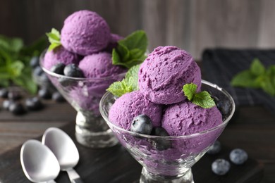 Photo of Tasty sorbet with blueberries and mint in dessert bowls on wooden table, closeup