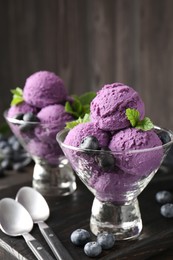 Photo of Tasty sorbet with blueberries and mint in dessert bowls on wooden table, closeup