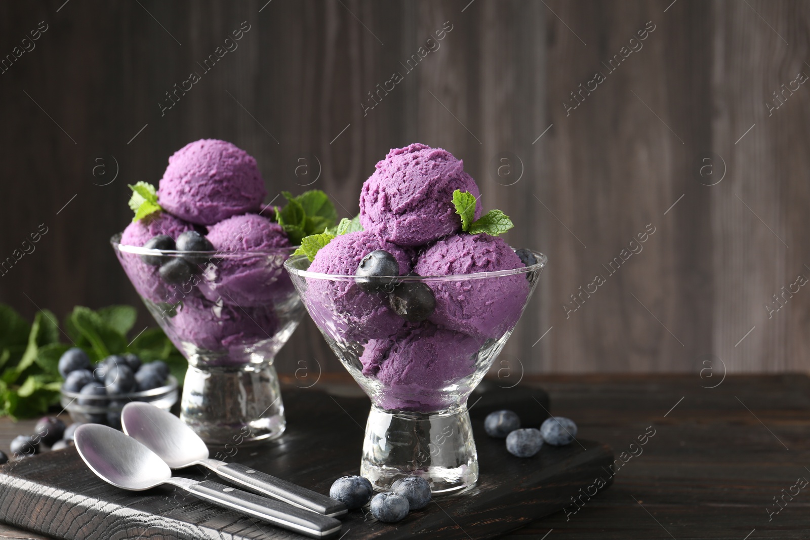 Tasty sorbet with blueberries and mint in dessert bowls on wooden table, closeup Photo of Tasty sorbet with blueberries and mint in dessert bowls on wooden table, closeup