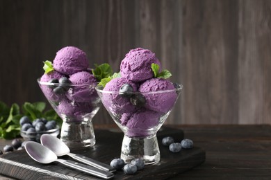 Photo of Tasty sorbet with blueberries and mint in dessert bowls on wooden table, closeup