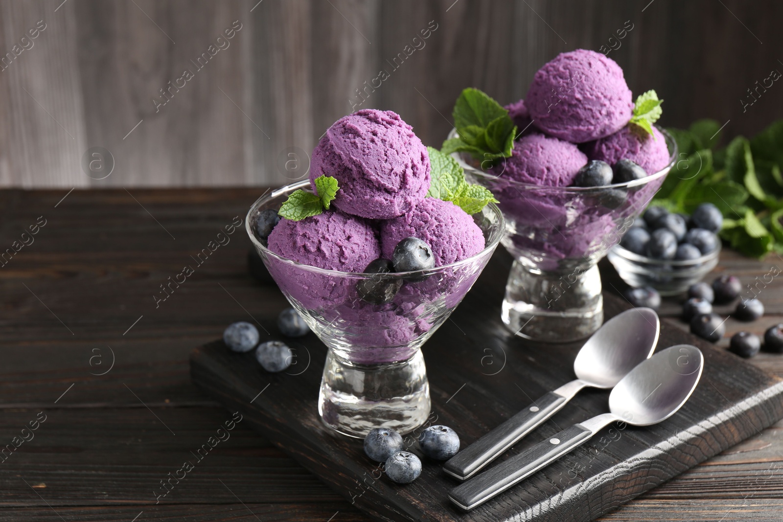 Photo of Tasty sorbet with blueberries and mint in dessert bowls on wooden table, closeup