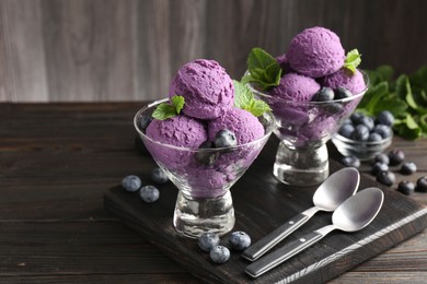 Photo of Tasty sorbet with blueberries and mint in dessert bowls on wooden table, closeup
