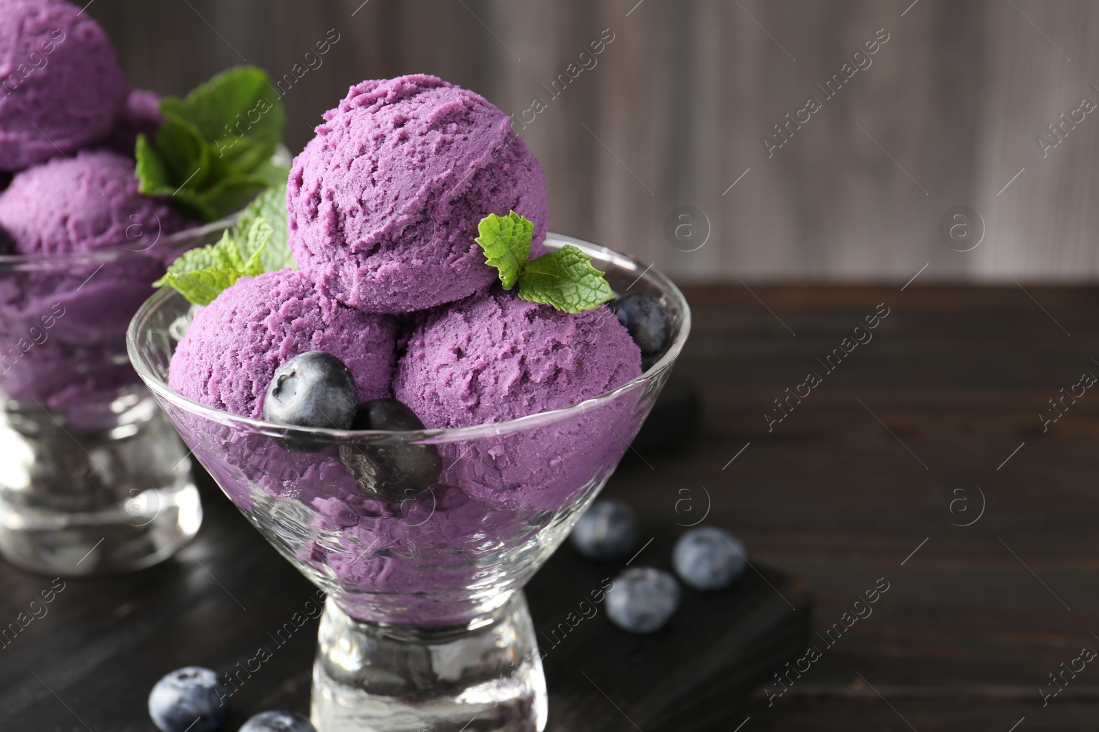 Tasty sorbet with blueberries and mint in dessert bowls on wooden table, closeup. Space for text Photo of Tasty sorbet with blueberries and mint in dessert bowls on wooden table, closeup. Space for text