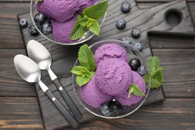 Photo of Tasty sorbet with blueberries and mint in dessert bowls on wooden table, top view