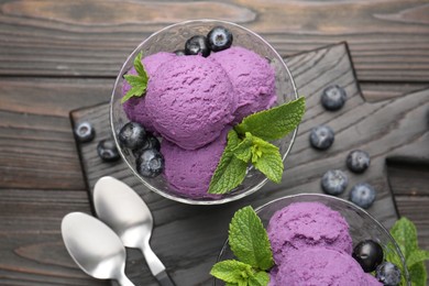 Photo of Tasty sorbet with blueberries and mint in dessert bowls on wooden table, top view