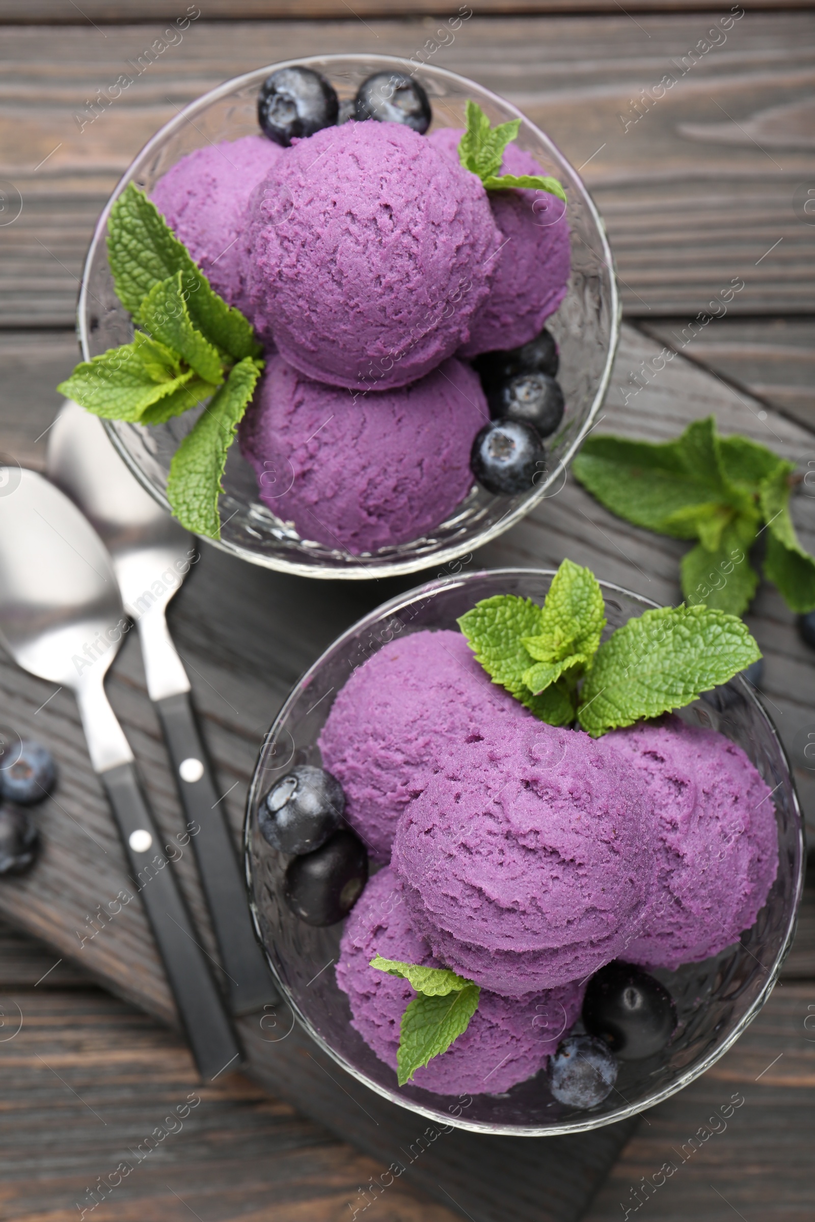 Tasty sorbet with blueberries and mint in dessert bowls on wooden table, top view Photo of Tasty sorbet with blueberries and mint in dessert bowls on wooden table, top view