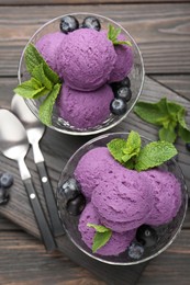 Photo of Tasty sorbet with blueberries and mint in dessert bowls on wooden table, top view