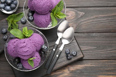 Photo of Tasty sorbet with blueberries and mint in dessert bowls on wooden table, flat lay. Space for text
