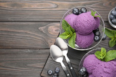 Photo of Tasty sorbet with blueberries and mint in dessert bowls on wooden table, flat lay. Space for text