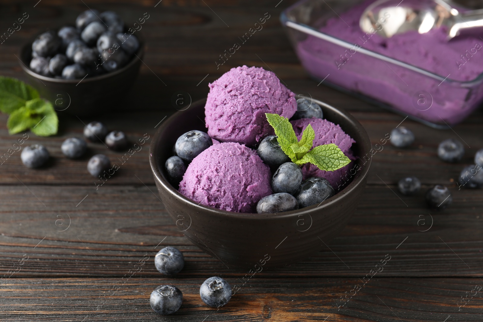 Tasty sorbet with blueberries and mint in bowl on wooden table, closeup Photo of Tasty sorbet with blueberries and mint in bowl on wooden table, closeup