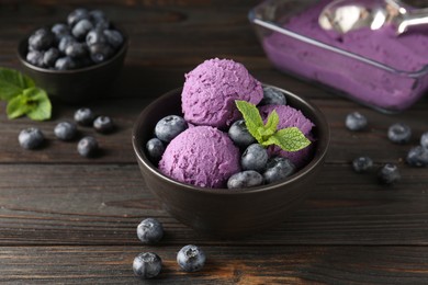 Photo of Tasty sorbet with blueberries and mint in bowl on wooden table, closeup