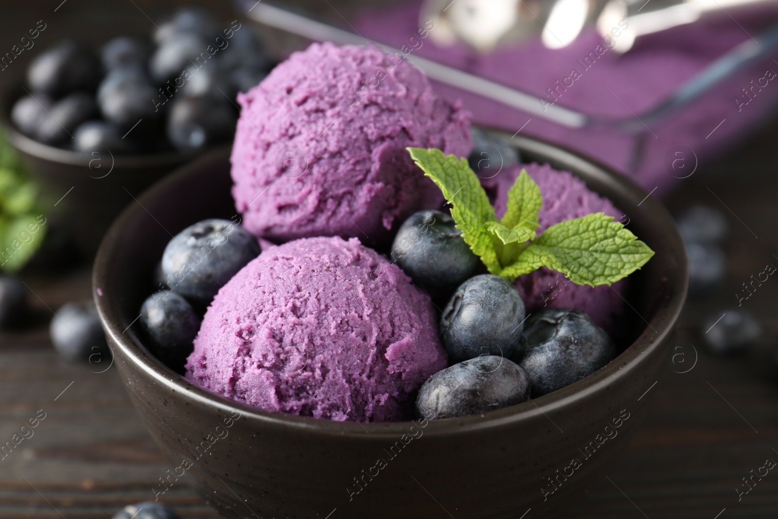 Tasty sorbet with blueberries and mint in bowl on wooden table, closeup Photo of Tasty sorbet with blueberries and mint in bowl on wooden table, closeup