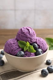 Photo of Tasty sorbet with blueberries and mint in bowl on table, closeup