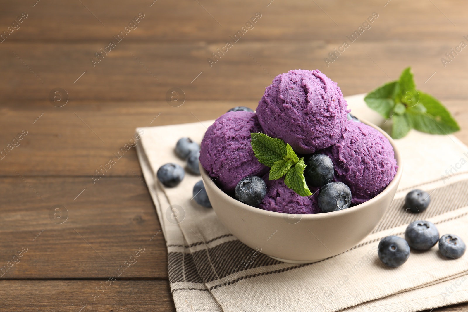 Tasty sorbet with blueberries and mint in bowl on wooden table, closeup. Space for text Photo of Tasty sorbet with blueberries and mint in bowl on wooden table, closeup. Space for text