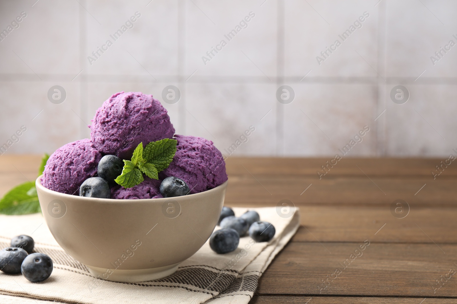 Tasty sorbet with blueberries and mint in bowl on wooden table, closeup. Space for text Photo of Tasty sorbet with blueberries and mint in bowl on wooden table, closeup. Space for text