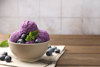Photo of Tasty sorbet with blueberries and mint in bowl on wooden table, closeup. Space for text