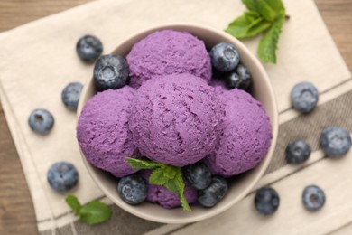 Photo of Tasty sorbet with blueberries and mint in bowl on table, top view