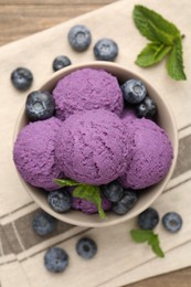 Photo of Tasty sorbet with blueberries and mint in bowl on table, top view