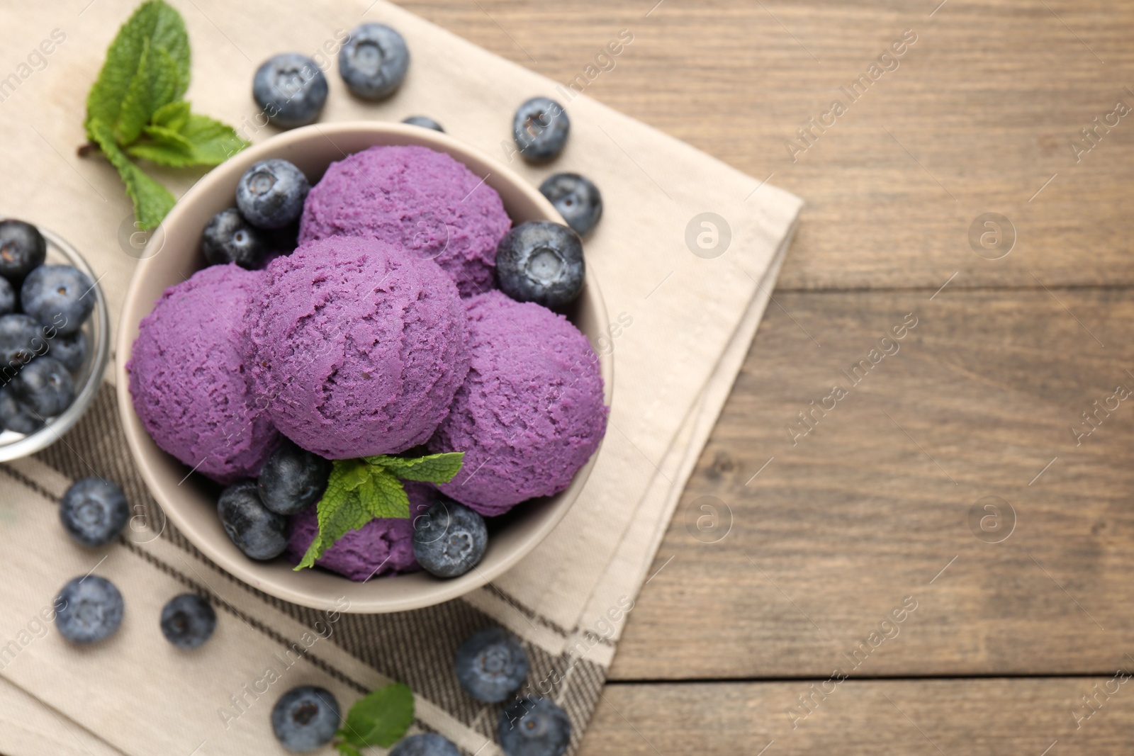 Tasty sorbet with blueberries and mint in bowl on wooden table, top view. Space for text Photo of Tasty sorbet with blueberries and mint in bowl on wooden table, top view. Space for text