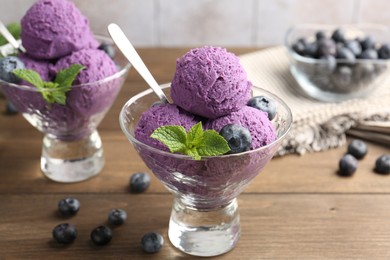 Photo of Tasty sorbet with blueberries and mint in dessert bowls on wooden table, closeup