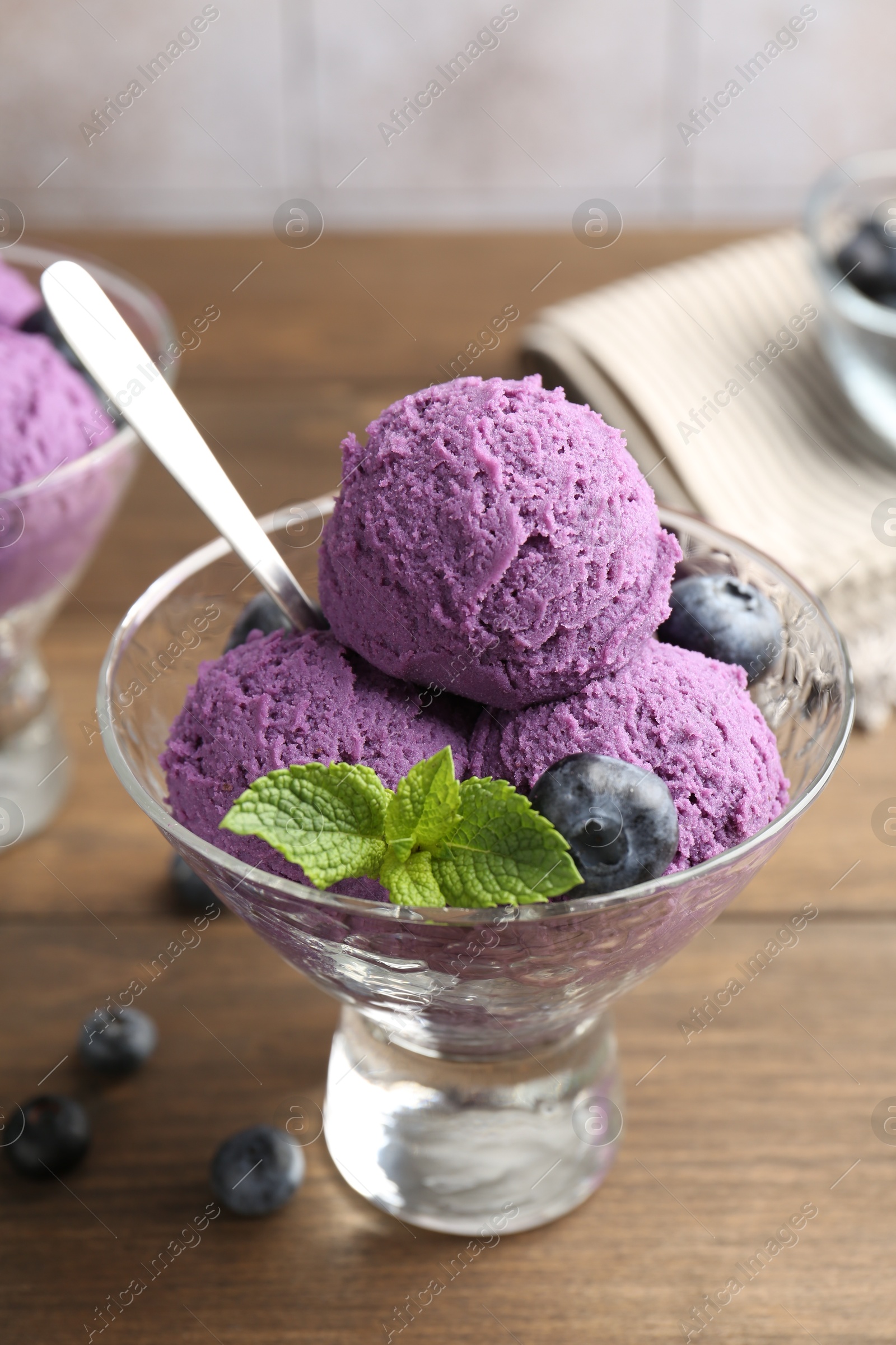Photo of Tasty sorbet with blueberries and mint in dessert bowl on wooden table, closeup