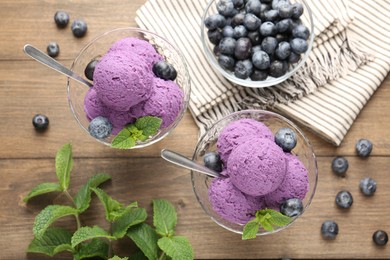Photo of Tasty sorbet with blueberries and mint in dessert bowls on wooden table, flat lay