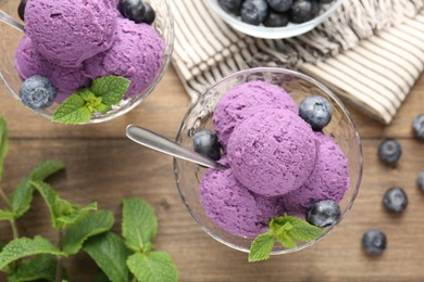 Photo of Tasty sorbet with blueberries and mint in dessert bowls on wooden table, flat lay