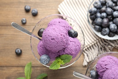 Photo of Tasty sorbet with blueberries and mint in dessert bowls on wooden table, flat lay