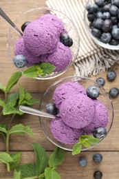 Photo of Tasty sorbet with blueberries and mint in dessert bowls on wooden table, flat lay