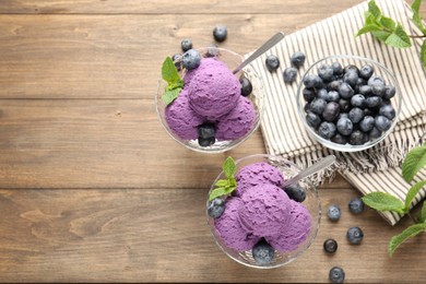 Photo of Tasty sorbet with blueberries and mint in dessert bowls on wooden table, flat lay. Space for text