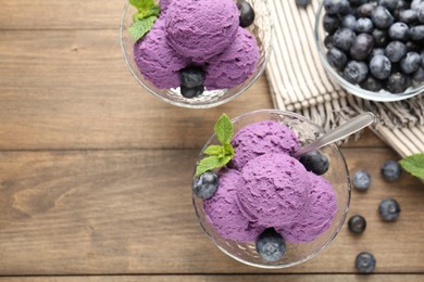 Photo of Tasty sorbet with blueberries and mint in dessert bowls on wooden table, flat lay. Space for text
