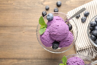 Photo of Tasty sorbet with blueberries and mint in dessert bowl on wooden table, flat lay. Space for text