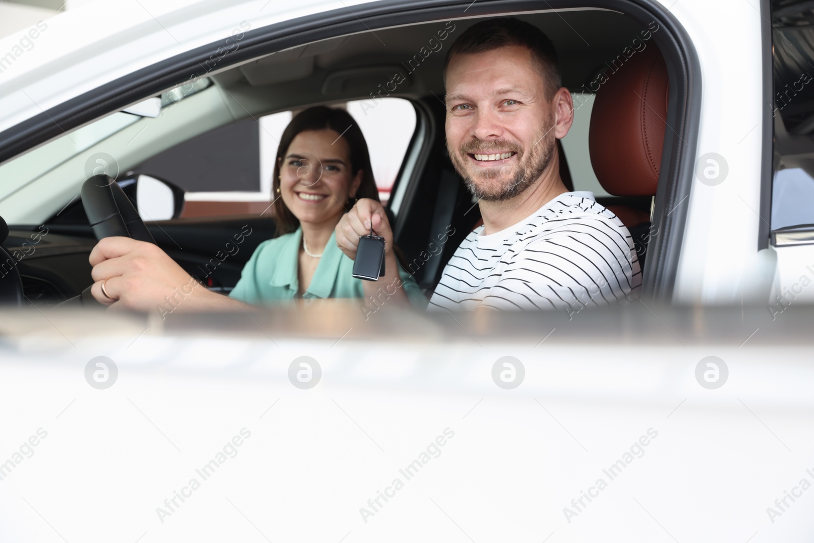 Photo of Happy family with keys inside new car