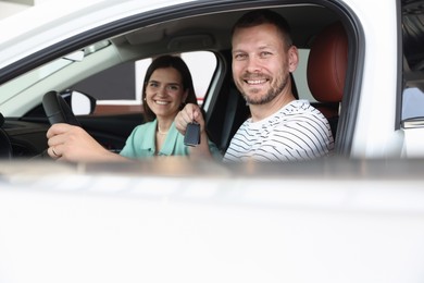 Photo of Happy family with keys inside new car