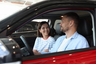 Photo of Happy family sitting inside new car. Luxury vehicle