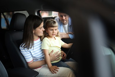 Photo of Family sitting inside new car. Luxury vehicle