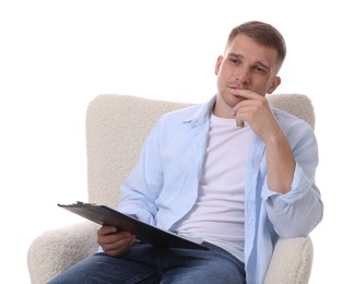 Photo of Thoughtful psychologist with clipboard sitting on armchair against white background