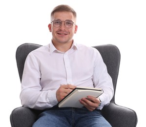Photo of Smiling psychologist in glasses with notepad sitting on armchair against white background