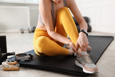 Photo of Sports injury. Young woman suffering from leg pain in fitness studio, closeup
