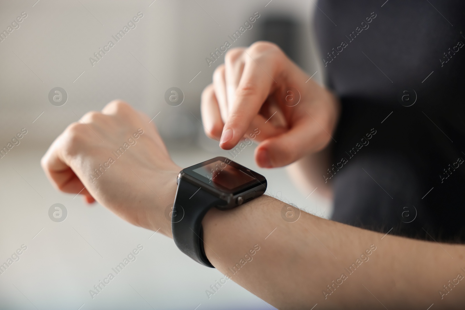 Woman checking fitness tracker during training indoors, closeup Photo of Woman checking fitness tracker during training indoors, closeup