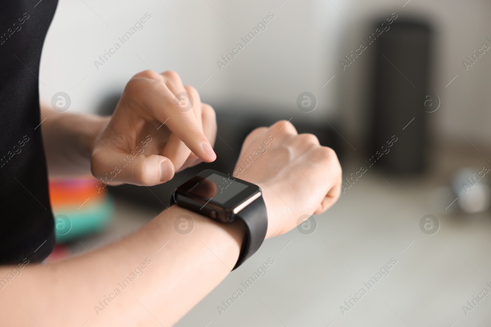Photo of Woman checking fitness tracker during training indoors, closeup. Space for text