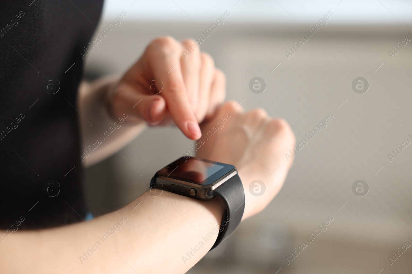 Woman checking fitness tracker during training indoors, closeup. Space for text Photo of Woman checking fitness tracker during training indoors, closeup. Space for text