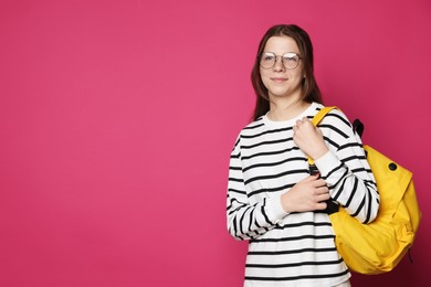 Photo of Teenage girl in glasses with backpack on crimson background, space for text