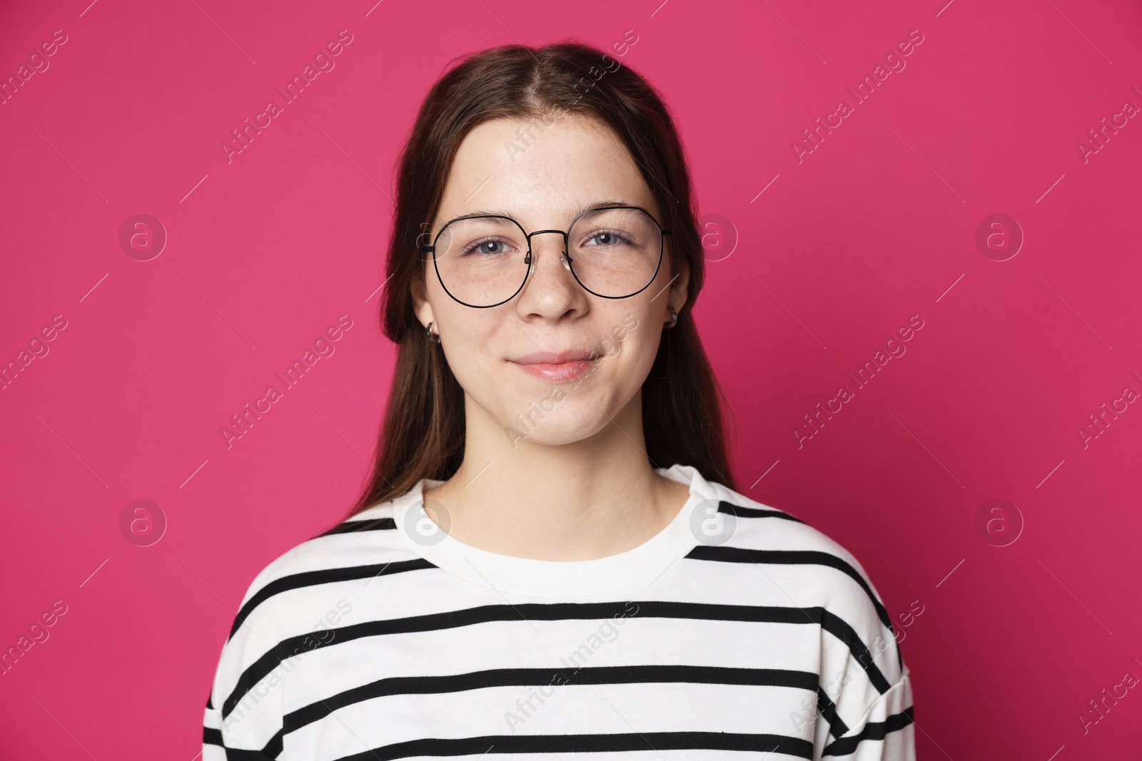 Teenage girl in glasses on crimson background Photo of Teenage girl in glasses on crimson background