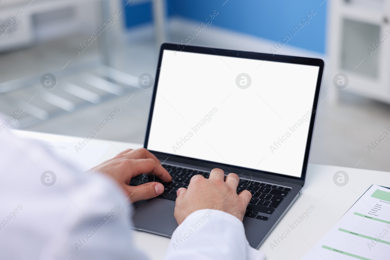 Doctor using laptop in clinic, closeup. Online medical consultation Photo of Doctor using laptop in clinic, closeup. Online medical consultation