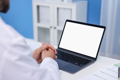 Photo of Doctor using laptop in clinic, closeup. Online medical consultation