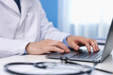 Photo of Doctor using laptop in clinic, closeup. Online medical consultation