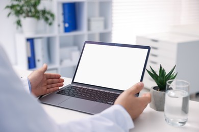 Photo of Doctor having online consultation via laptop in clinic, closeup