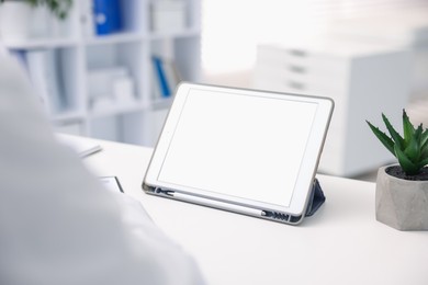Photo of Doctor having online consultation via tablet in clinic, closeup