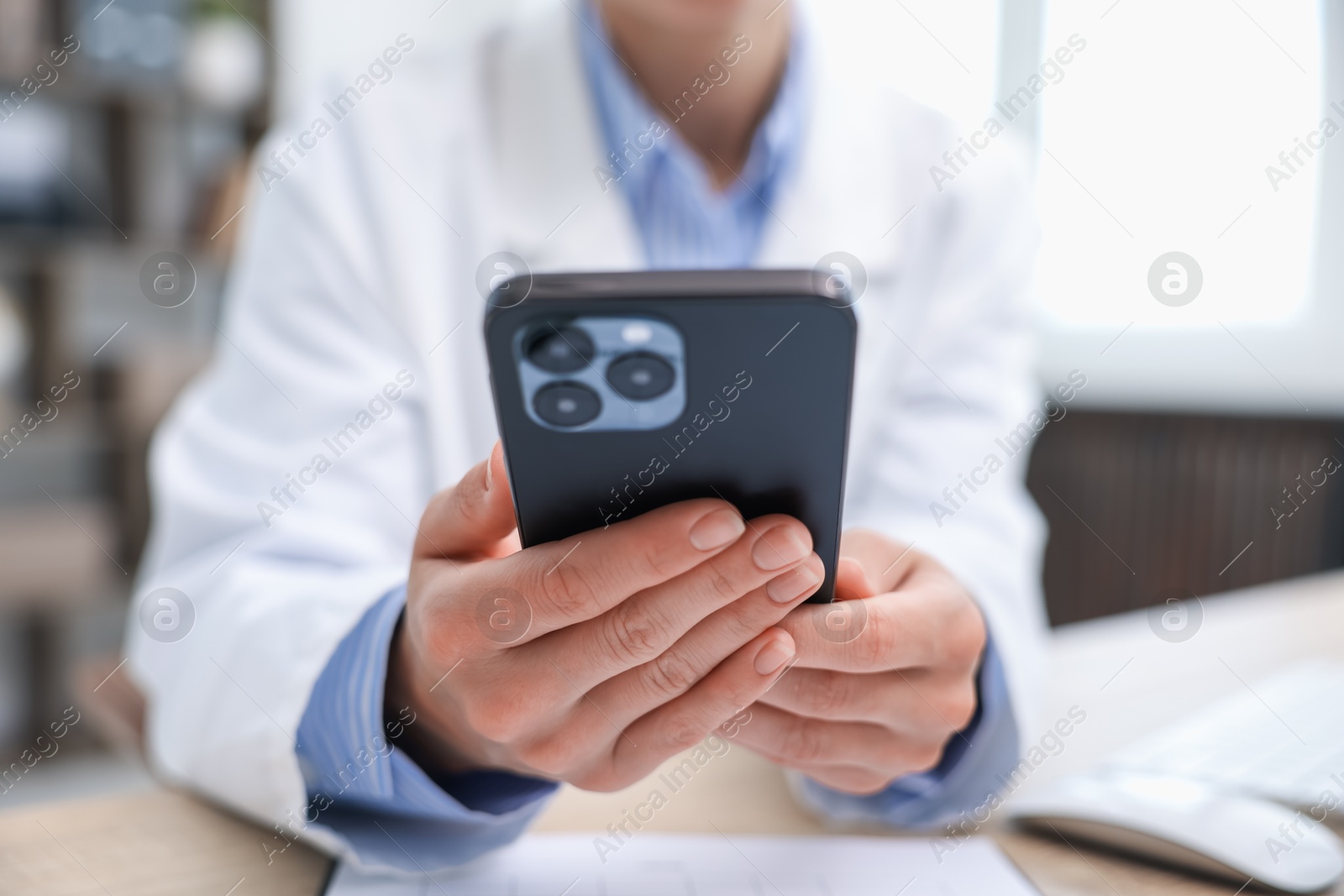 Doctor with smartphone in clinic, closeup. Online medical consultation Photo of Doctor with smartphone in clinic, closeup. Online medical consultation